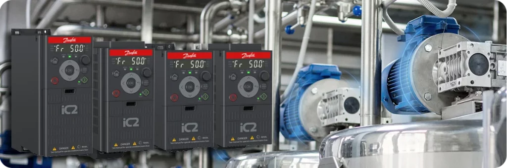 Variadores de frecuencia Danfoss iC2-Micro integrados sobre una instalación industrial de bombeo con motores eléctricos y tuberías de proceso.